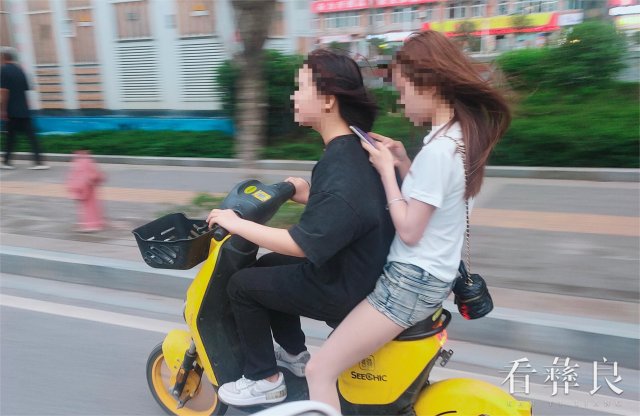 5.6月10日，滨河大道上两人同骑一辆共享单车.jpg